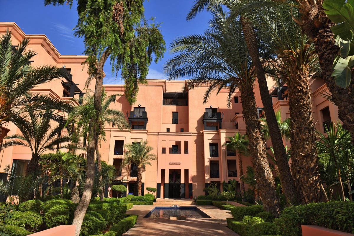 Façade de l'hôtel Mövenpick Mansour Eddahbi, bassin aux reflets et jardins